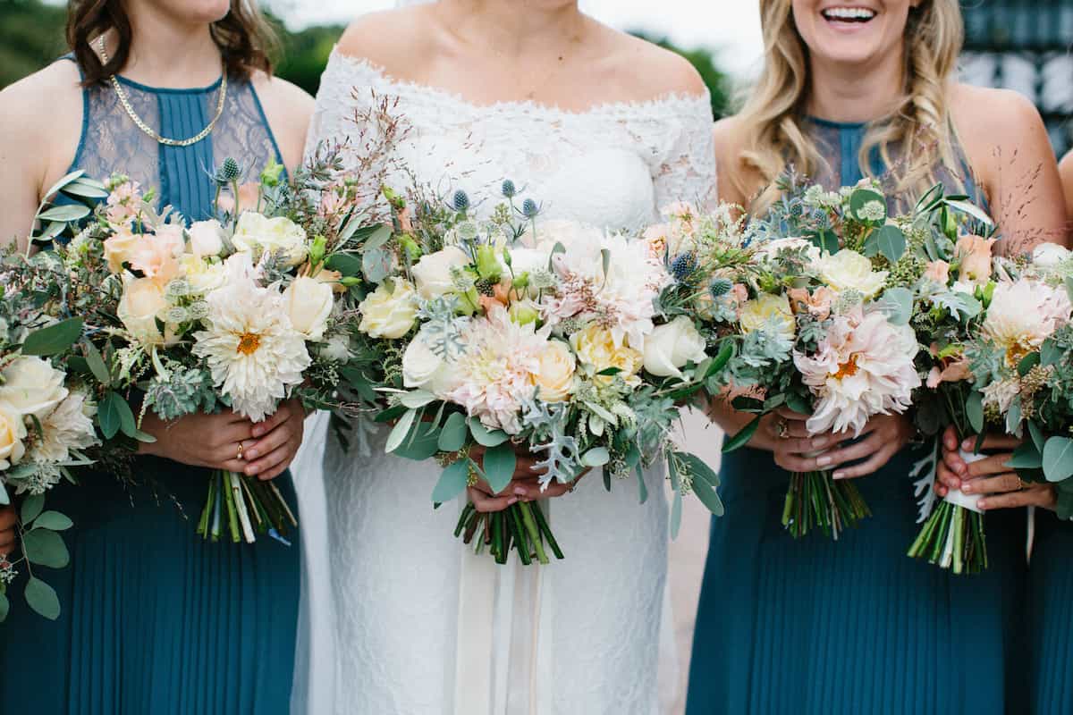 A bride and bridesmaids holding pale coloured bouquets