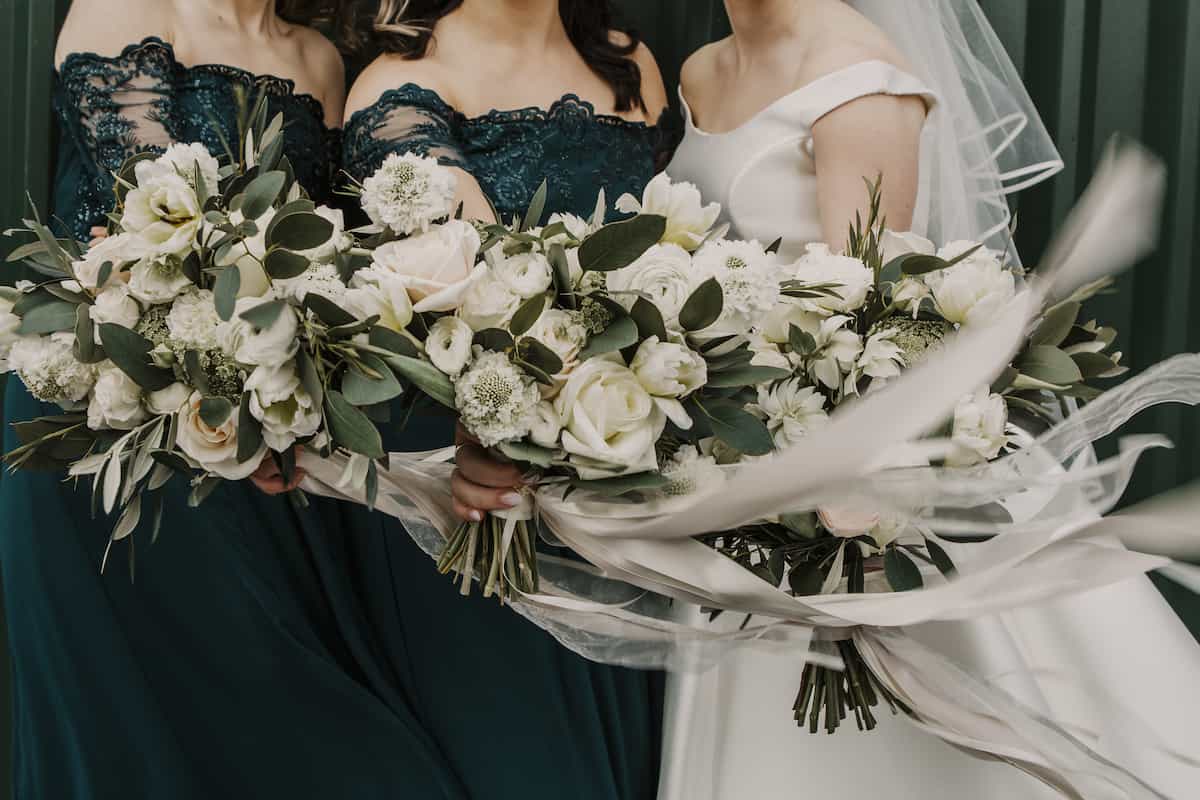 A bride and bridesmaids holding white bouquets