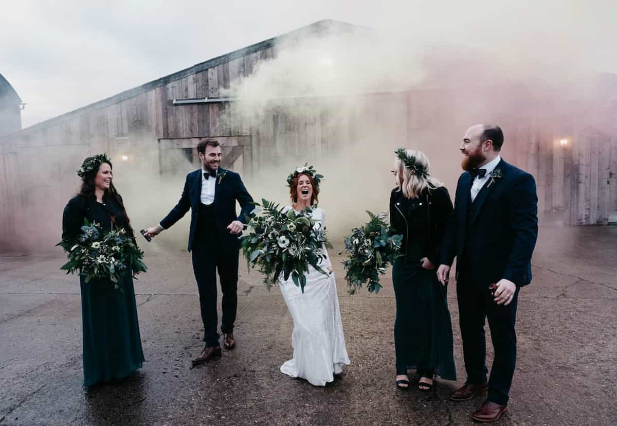 A happy wedding party holding bouquets and wearing flower crowns